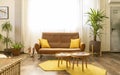 Interior home decoration. Corner in a living room / bedroom, with brown sofa, two wooden tables. Royalty Free Stock Photo