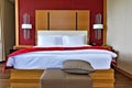 The interior of the hotel. Double bed with white linen and red bedspread. Royalty Free Stock Photo