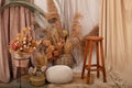 Interior Of House Is Decor In Brown Tones: Wooden Chair, Knitted Pouf, Wicker Baskets, Vases With Dried Flowers And Pampas Grass.