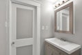 Interior of house in a bathroom with sink, lights, and door. Royalty Free Stock Photo