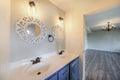 Interior of a house with a view of double vanity sink and an empty room with antique chandelier Royalty Free Stock Photo