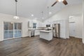 Interior of a house with white walls, parquet floor, hanging lamps, and a patio sliding door Royalty Free Stock Photo