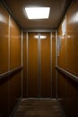 Interior inside a closed clean old Soviet elevator car lined with wood