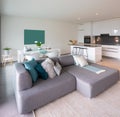 Interior of a kitchen open to the living room and dining room of a modern apartment.