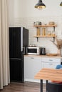 Interior of kitchen in rustic style with vintage kitchen ware and wooden wall. White furniture and wooden decor in