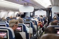 Interior of large commercial airplane with passengers on seats waiting to taik off. Royalty Free Stock Photo