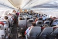 Interior of large commercial airplane with passengers on their seats during flight. Royalty Free Stock Photo