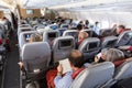 Interior of large commercial airplane with passengers on their seats during flight. Royalty Free Stock Photo