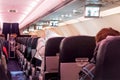 Interior of large passengers airplane with people on seats.