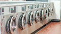 Interior of laundromat with multiple washing machines standing in perfect order Royalty Free Stock Photo