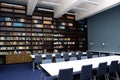 The interior of the library, blue and brown colors. Bookcases with books, white tables Royalty Free Stock Photo