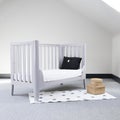 Interior of light baby room with a cozy crib and woven wicker boxes for clothes or accessories Royalty Free Stock Photo