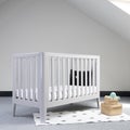 Interior of light baby room with a modern crib and woven wicker boxes for clothes or accessories Royalty Free Stock Photo
