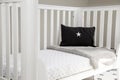 Interior of a light baby room with a soft pillow and blanket on a modern whitewashed cozy crib Royalty Free Stock Photo