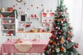 Interior light grey kitchen and red christmas decor. Preparing lunch at home on the kitchen concept. Focus on tree Royalty Free Stock Photo