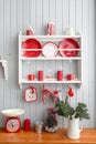 Shelves with dishes. Interior light grey kitchen and red christmas decor. Preparing lunch at home on the kitchen concept Royalty Free Stock Photo