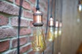 Interior lighting decoration with vintage electric light bulb with bokeh effect in background . Brick wall on the Royalty Free Stock Photo
