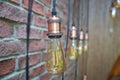 Interior lighting decoration with vintage electric light bulb with bokeh effect in background . Brick wall on the Royalty Free Stock Photo