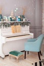 Interior living room is decorated in classic style with white piano, Christmas tree and gifts. New Year decoration. Piano in room Royalty Free Stock Photo