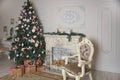 Interior of the living room with a fireplace, decorated for the New Year with a big Christmas tree and lots of presents Royalty Free Stock Photo