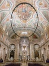 interior of Loreto church in Lisbon with large oval-shaped lamp.