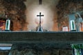 Interior of a medieval ruined church with altar cross and candles