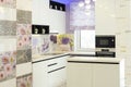 Interior of minimalistic luxury kitchen with white walls, with built in cooker and comfortable cupboards