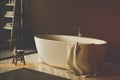 White bathtub in a black bathroom corner toned Royalty Free Stock Photo