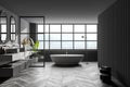 Interior of modern bathroom with grey wooden walls, parquet on floor, double sink with two mirrors above it and comfortable white Royalty Free Stock Photo
