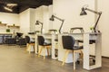 Manicure tables with lamps and cozy chairs in the barbershop