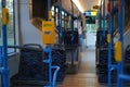 interior of a modern bus, featuring patterned blue seats, yellow ticket validators, and blue handrails Royalty Free Stock Photo
