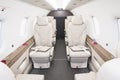 Interior of a modern business turboprop aircraft, light leather seats with lowered armrests Royalty Free Stock Photo