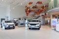 interior of a modern car dealership with white SUVs, premium showroom, photo with blur
