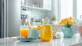 In the interior of a modern comfortable kitchen, there are colorful cups and teapots, orange juice in a glass, utensils Royalty Free Stock Photo