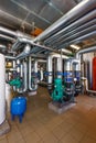 The interior of a modern gas boiler house with pumps, valves, a