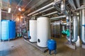 The interior of a modern gas boiler house with pumps, valves, a