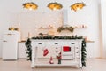 Interior of a modern kitchen with an island, a sink, cabinets in a new elite house, decorated in a Christmas style Royalty Free Stock Photo