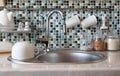 Interior of modern kitchen. Kitchen faucet, sink and various ceramic white dishes Royalty Free Stock Photo