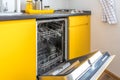 Interior of the modern kitchen with opened Dishwasher in loft flat apartment in minimalistic style with yellow color Royalty Free Stock Photo