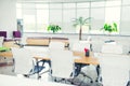 Interior of modern light empty open space office with big windows, table desks, chairs and green plants. Coworking workplace conce Royalty Free Stock Photo