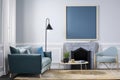 Interior of modern living room with blue armchairs and fireplace. Mock up, 3D Rendering, Mockup poster frame on the wall in a Royalty Free Stock Photo