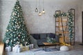 Interior of modern living room with comfortable sofa decorated with Christmas tree and gifts