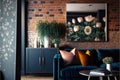 The interior of a modern living room with a dark blue sofa next to a brick wall on which a horizontal poster hangs, in the Royalty Free Stock Photo