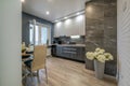 Interior of the modern luxure kitchen in studio apartments in minimalistic style with dark color with granite walls