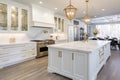 Interior of modern luxurious classic kitchen. White cabinets with gilded handles, kitchen island with white marble
