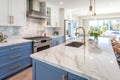 Interior of modern luxurious kitchen classic style. White and blue cabinets with gilded handles, kitchen island with Royalty Free Stock Photo