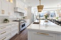 Interior of modern luxurious kitchen classic style. White cabinets with gilded handles, kitchen island with white marble Royalty Free Stock Photo