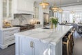 Interior of modern luxurious kitchen classic style. White cabinets with gilded handles, kitchen island with white marble