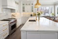 Interior of modern luxurious kitchen classic style. White cabinets with gilded handles, kitchen island with white marble Royalty Free Stock Photo