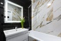 Interior of a modern small bathroom with white and black marble tiles